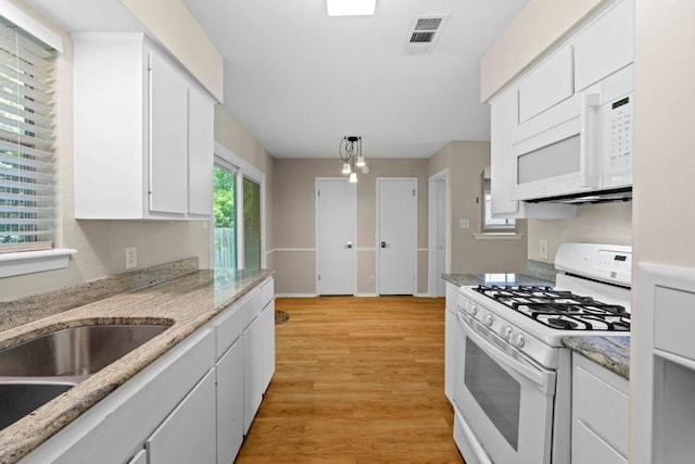 3103 Steck Ave, Austin, TX 78757 - kitchen with white appliances, light wood-style floors, white cabinetry, and a sink