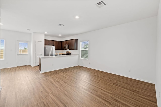 504 Blanco Vis, Georgetown, TX 78626 - unfurnished living room with healthy amount of natural light, light wood-style flooring, a sink, recessed lighting, and baseboards