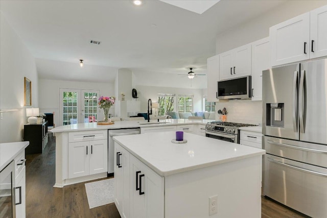 10807 Pinkney Ln, Austin, TX 78739 - kitchen featuring stainless steel appliances, a sink, open floor plan, a peninsula, and a center island