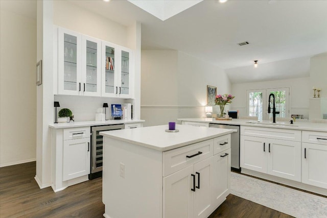 10807 Pinkney Ln, Austin, TX 78739 - kitchen with a sink, stainless steel dishwasher, wine cooler, dark wood-style flooring, and glass insert cabinets