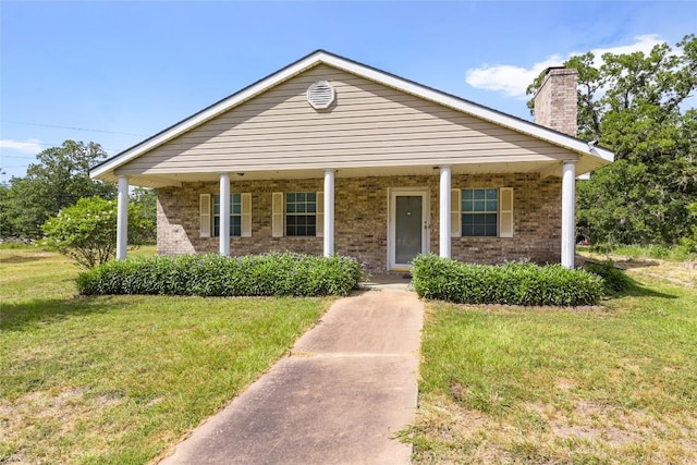 356 Cedar Ln, Cedar Creek, TX 78612 - view of front of house featuring a porch, a front yard, and brick siding