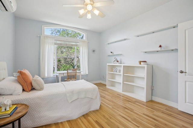 2302 Bahama Rd, Austin, TX 78733 - bedroom featuring light wood-style floors, baseboards, a wall unit AC, and a ceiling fan