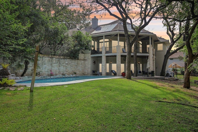 2302 Bahama Rd, Austin, TX 78733 - back of property featuring a balcony, a patio area, a lawn, stucco siding, and an outdoor pool