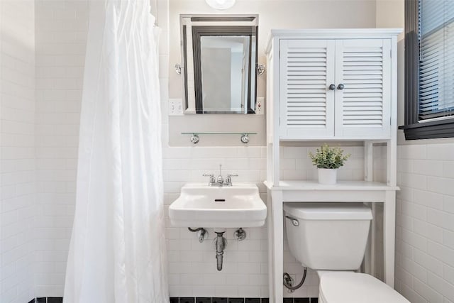 7517 Saint Louis St, Austin, TX 78757 - bathroom featuring tile walls, toilet, curtained shower, a sink, and wainscoting