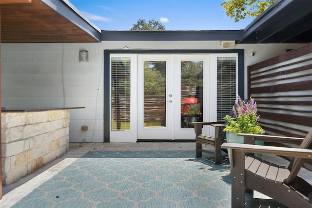 7517 Saint Louis St, Austin, TX 78757 - view of exterior entry with french doors, concrete block siding, a patio, and a surveillance system