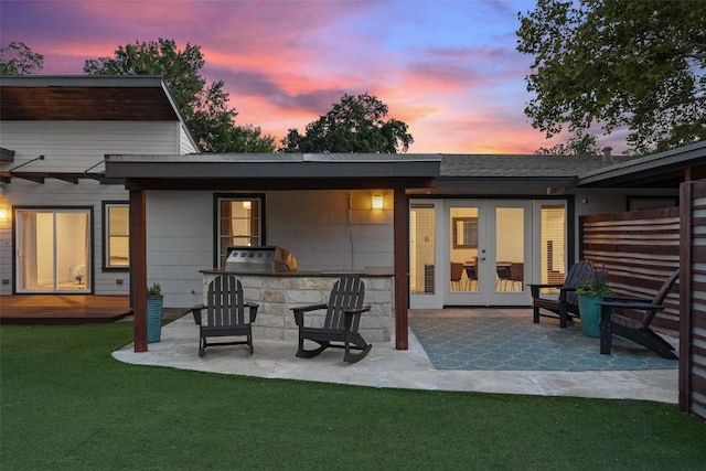 7517 Saint Louis St, Austin, TX 78757 - back of property with french doors, a patio area, a bar, a lawn, and area for grilling