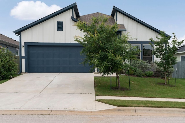 9904 Comely Bnd, Manor, TX 78653 - view of front of house with board and batten siding, driveway, an attached garage, and a front lawn