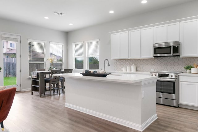 9904 Comely Bnd, Manor, TX 78653 - kitchen featuring appliances with stainless steel finishes, tasteful backsplash, light wood-style flooring, light countertops, and recessed lighting