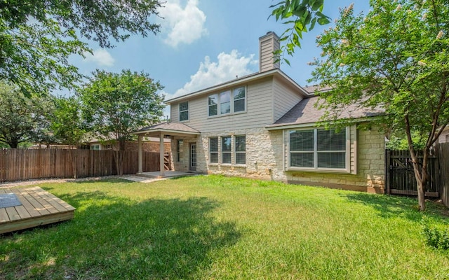 480 Middle Crk, Buda, TX 78610 - back of house with stone siding, a chimney, a deck, and a patio
