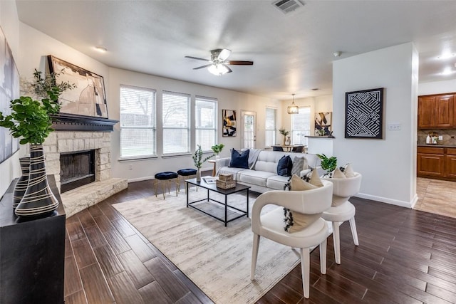 480 Middle Crk, Buda, TX 78610 - living area with a ceiling fan, baseboards, a stone fireplace, and dark wood-type flooring