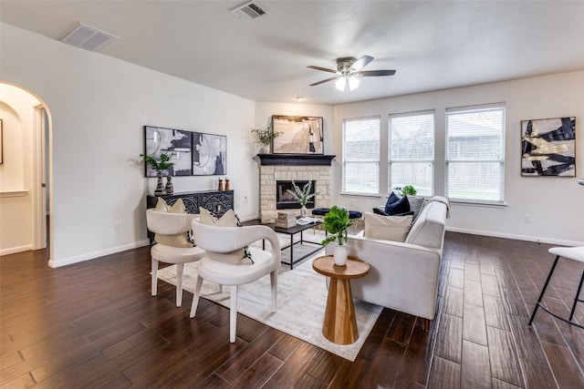 480 Middle Crk, Buda, TX 78610 - living room featuring arched walkways, dark wood finished floors, a ceiling fan, a fireplace, and baseboards