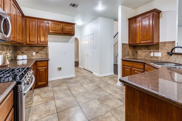 480 Middle Crk, Buda, TX 78610 - kitchen featuring a sink, appliances with stainless steel finishes, arched walkways, brown cabinets, and recessed lighting