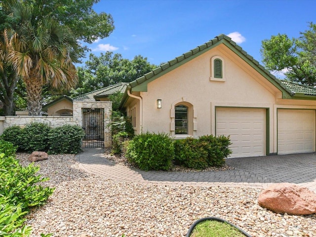 105 San Saba Ct, Horseshoe Bay, TX 78657 - mediterranean / spanish home with decorative driveway, an attached garage, stucco siding, and a tile roof