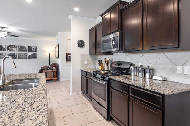 1317 Gaviota Ln, Leander, TX 78641 - kitchen with appliances with stainless steel finishes, a sink, crown molding, a ceiling fan, and backsplash