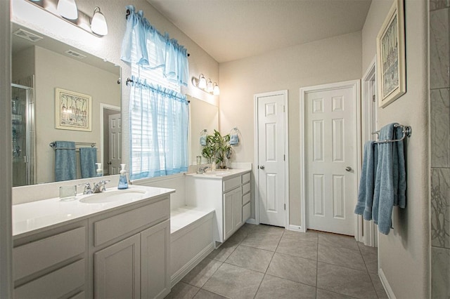 205 Michaelis Dr, Leander, TX 78641 - bathroom with two vanities, tile patterned flooring, and a shower stall