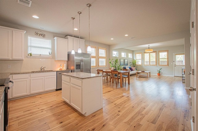205 Michaelis Dr, Leander, TX 78641 - kitchen with stainless steel appliances, a center island, open floor plan, healthy amount of natural light, and recessed lighting