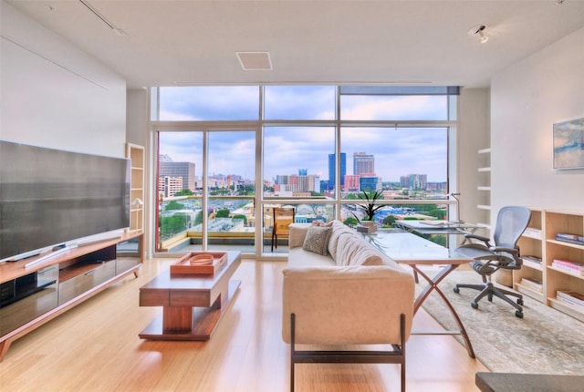 555 E 5th St Unit 809, Austin, TX 78701 - living area with a view of skyline, expansive windows, wood finished floors, a desk, and plenty of natural light