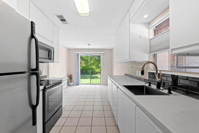 3105 Steck Ave, Austin, TX 78757 - kitchen with stainless steel appliances, a sink, white cabinets, and light countertops