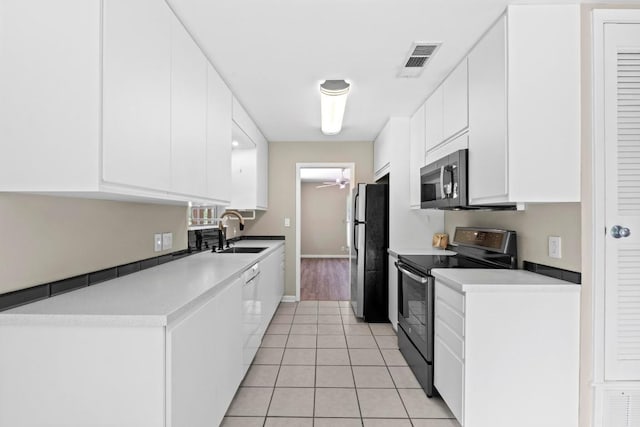 3105 Steck Ave, Austin, TX 78757 - kitchen featuring appliances with stainless steel finishes, a sink, a ceiling fan, white cabinets, and light tile patterned floors