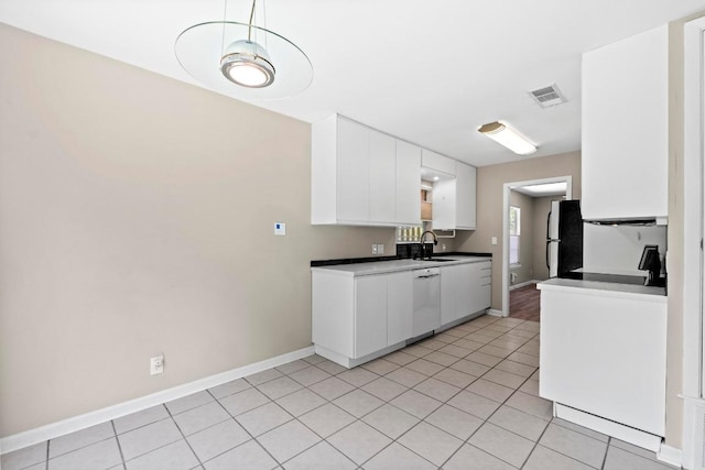 3105 Steck Ave, Austin, TX 78757 - kitchen featuring freestanding refrigerator, white dishwasher, white cabinets, and light tile patterned floors