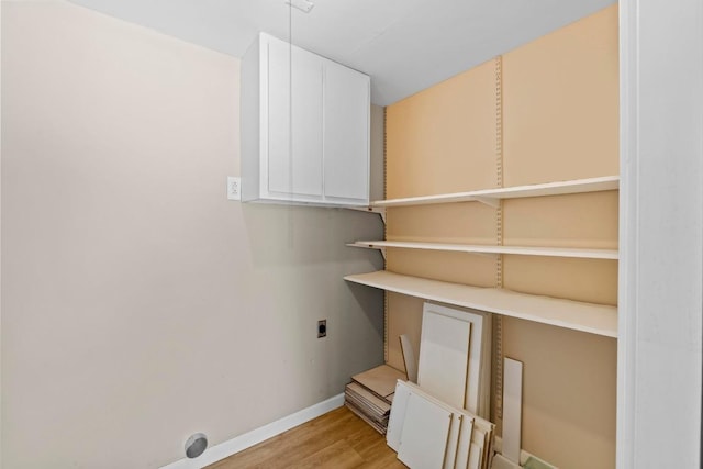 3105 Steck Ave, Austin, TX 78757 - laundry area with hookup for an electric dryer, light wood-type flooring, baseboards, and cabinet space