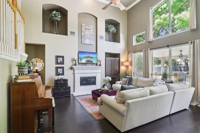 20737 Kearney Hill Rd, Pflugerville, TX 78660 - living room with ceiling fan, a glass covered fireplace, a high ceiling, and wood finished floors
