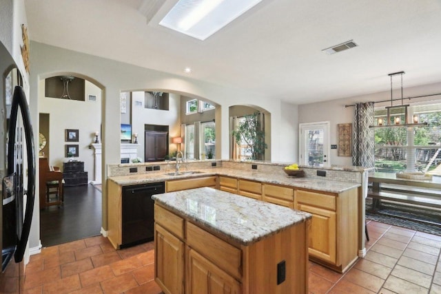 20737 Kearney Hill Rd, Pflugerville, TX 78660 - kitchen featuring black appliances, a center island, arched walkways, light stone countertops, and recessed lighting