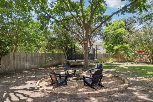 20737 Kearney Hill Rd, Pflugerville, TX 78660 - fenced backyard featuring a trampoline and an outdoor fire pit
