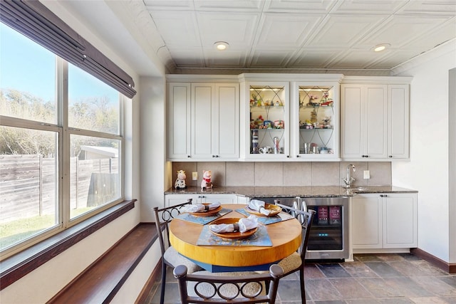 6002 Rain Creek Pkwy, Austin, TX 78759 - dining room featuring beverage cooler, baseboards, wet bar, recessed lighting, and an ornate ceiling