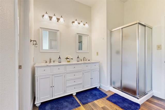 6002 Rain Creek Pkwy, Austin, TX 78759 - full bathroom with double vanity, a stall shower, and wood finished floors