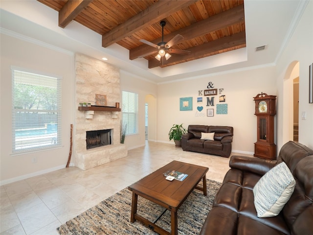 7 Redwood Cir, Wimberley, TX 78676 - living area featuring arched walkways, wooden ceiling with exposed beams, healthy amount of natural light, a ceiling fan, and a stone fireplace