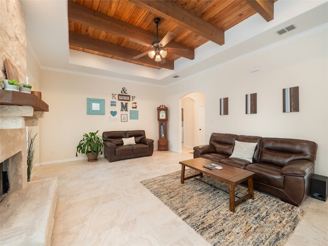 7 Redwood Cir, Wimberley, TX 78676 - living room with wood ceiling with exposed beams, arched walkways, a ceiling fan, a high end fireplace, and a tray ceiling