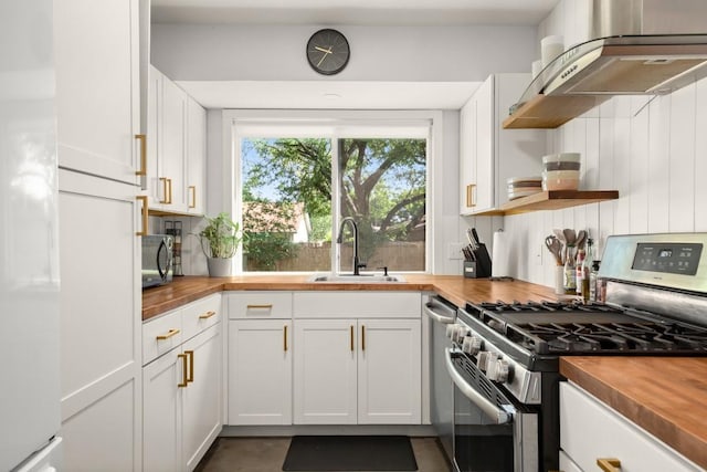 1514 Turtle Creek Blvd, Austin, TX 78745 - kitchen featuring wood counters, stainless steel appliances, range hood, a sink, and white cabinetry