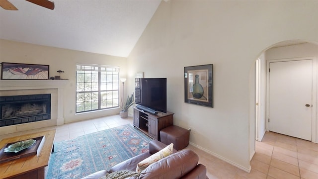 4006 Spanish Oak Ln, Dripping Springs, TX 78620 - tiled living area featuring a fireplace, ceiling fan, arched walkways, high vaulted ceiling, and baseboards