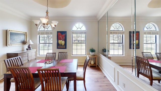 4006 Spanish Oak Ln, Dripping Springs, TX 78620 - dining area featuring wood finished floors, a chandelier, crown molding, a decorative wall, and a wainscoted wall