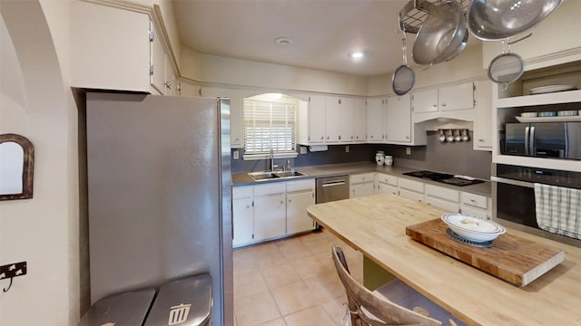 4006 Spanish Oak Ln, Dripping Springs, TX 78620 - kitchen with stainless steel appliances, a sink, white cabinetry, and light tile patterned floors