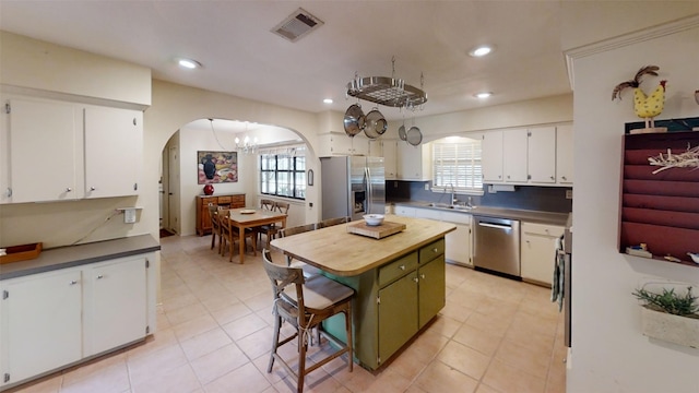 4006 Spanish Oak Ln, Dripping Springs, TX 78620 - kitchen featuring stainless steel appliances, arched walkways, a sink, white cabinetry, and healthy amount of natural light