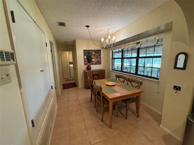 4006 Spanish Oak Ln, Dripping Springs, TX 78620 - dining area featuring light tile patterned flooring, a chandelier, a textured ceiling, and baseboards