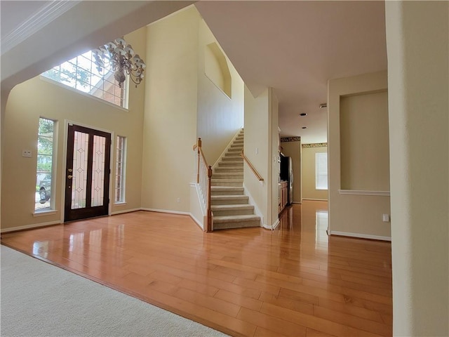 foyer entrance with stairs, plenty of natural light, and wood finished floors
