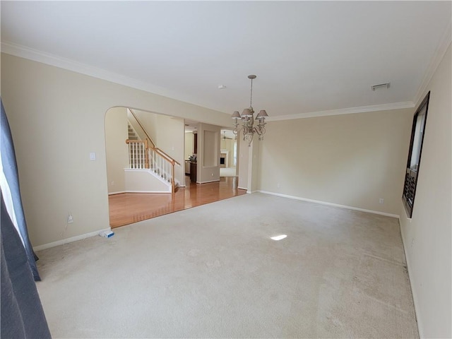 unfurnished living room featuring carpet, a chandelier, ornamental molding, stairs, and baseboards