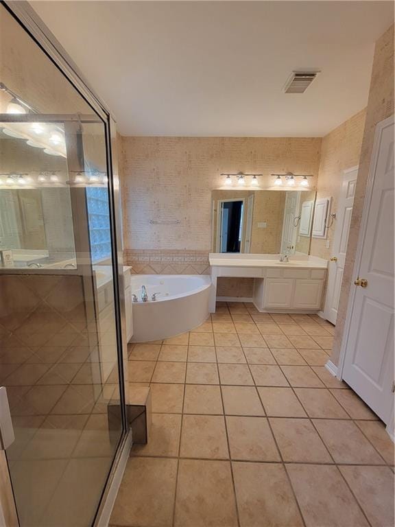 bathroom with tile patterned floors, a bath, double vanity, and a shower stall