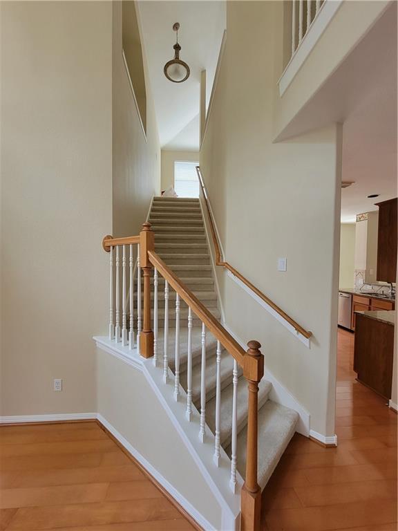 staircase with wood finished floors and baseboards