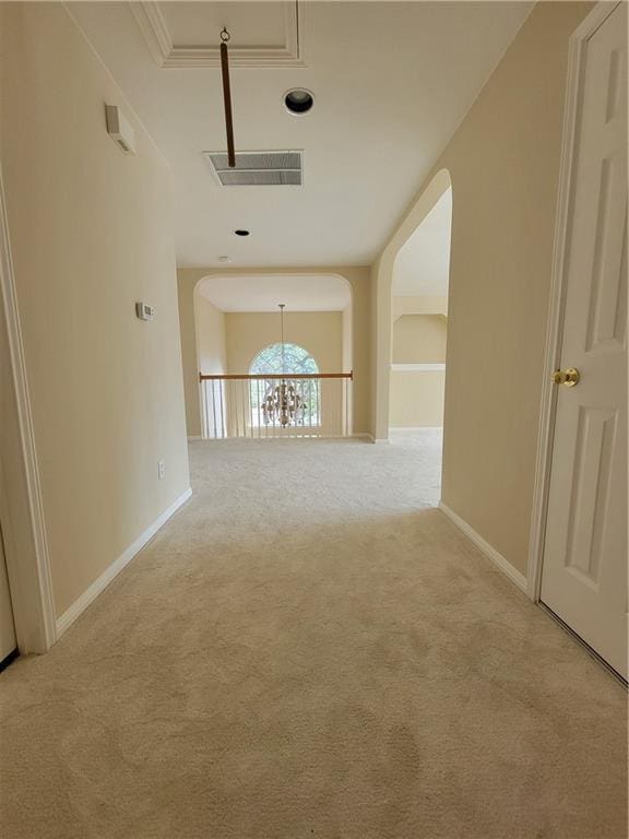 hall with light carpet, arched walkways, and baseboards