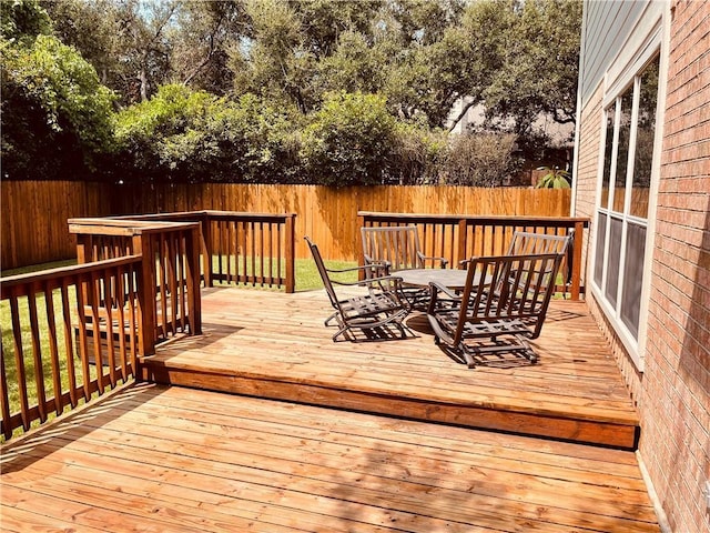 wooden terrace featuring a fenced backyard and outdoor dining space
