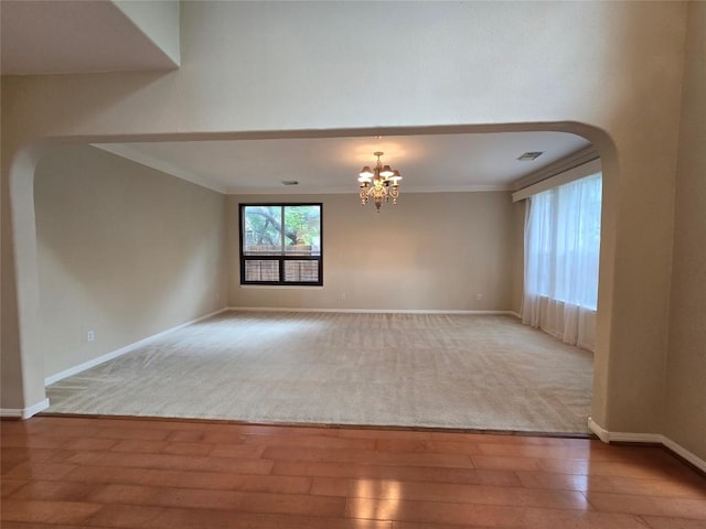 1411 Hunter Ace Way, Cedar Park, TX 78613 - carpeted empty room with wood-type flooring, a chandelier, ornamental molding, and arched walkways