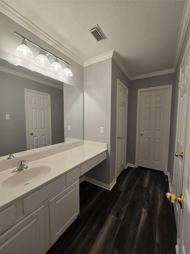 1411 Hunter Ace Way, Cedar Park, TX 78613 - bathroom featuring vanity, wood finished floors, ornamental molding, and a textured ceiling