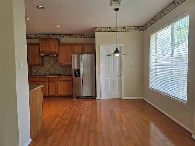 1411 Hunter Ace Way, Cedar Park, TX 78613 - kitchen featuring stainless steel refrigerator with ice dispenser, brown cabinets, plenty of natural light, and recessed lighting