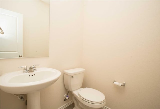 1036 Hillrose Dr, Leander, TX 78641 - half bathroom featuring baseboards, toilet, and a sink