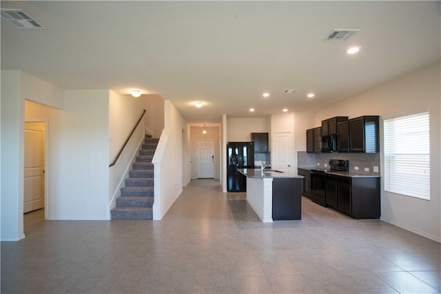 1036 Hillrose Dr, Leander, TX 78641 - kitchen with black appliances, a sink, an island with sink, decorative backsplash, and recessed lighting