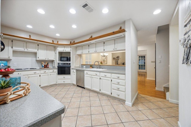 11900 Tunnel Trl, Manchaca, TX 78652 - kitchen with black oven, stainless steel dishwasher, a sink, built in microwave, and light tile patterned floors
